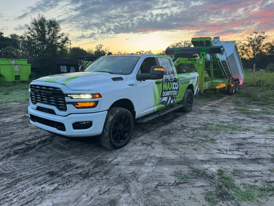 MAXCO truck picking up a full dumpster for disposal