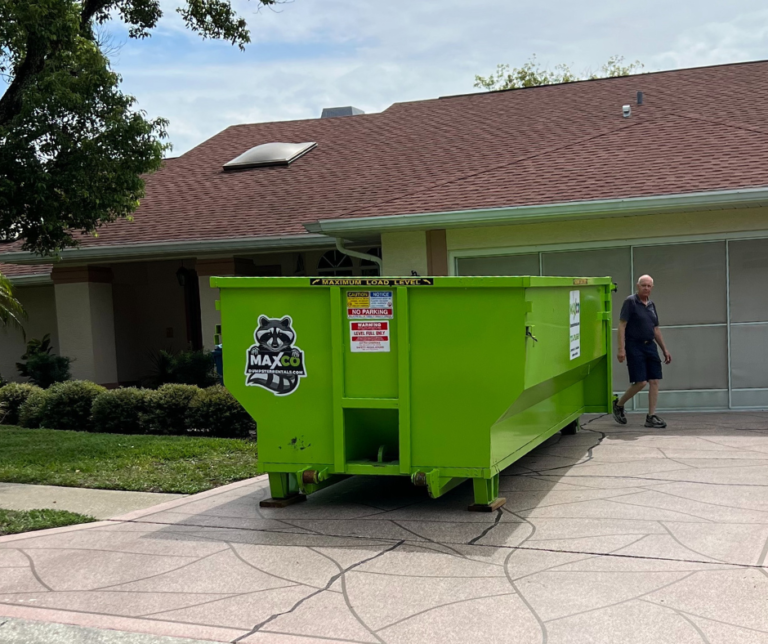 A neon green residential dumpster rental sitting on a beige driveway in new port richey